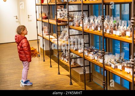 Dresde, Allemagne - 19 octobre 2024 : petite fille choisissant le chocolat dans un magasin spécialisé pour le chocolat et le cacao par Otto Ruger à Dresde, Allemagne Banque D'Images