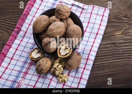 Les cerneaux de noix entiers et sur la vieille table de bois et torchon Banque D'Images
