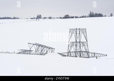 Construction de pylônes haute tension en hiver. Supports de ligne de transmission d'énergie assemblés, prêts pour l'installation Banque D'Images