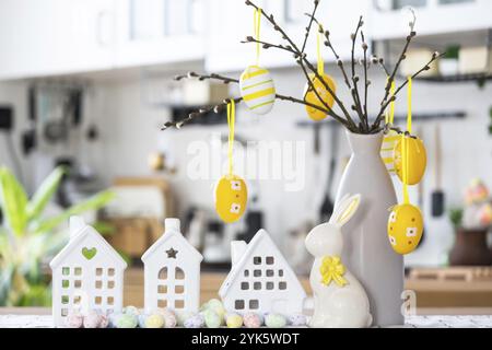 Clé de maison de maison confortable avec décor de Pâques avec lapin et œufs sur la table de la cuisine. Construction, conception, projet, déménagement à une nouvelle maison, hypothèque, assurance Banque D'Images