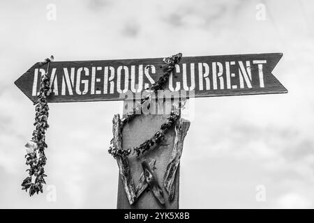 Un dangereux panneau de courant plein de leis à l'entrée de la plage de Waimea à Oahu, Hawaï Banque D'Images