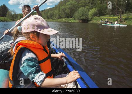 Excursion en kayak en famille. Père et fille, couple de personnes âgées et bateau à rames seniora sur la rivière, une randonnée dans l'eau, une aventure d'été. Écologique Banque D'Images