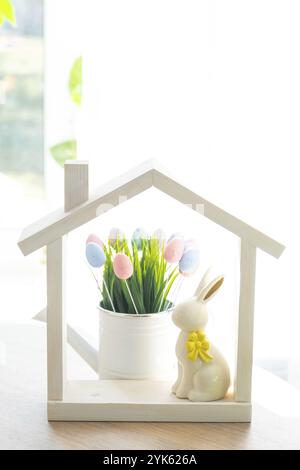 Petite maison de maison confortable avec décor de Pâques avec lapin et oeufs sur la table de la cuisine. Bâtiment, conception, projet, déménagement à la nouvelle maison, hypothèque, insuranc Banque D'Images