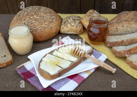 Tranche de pain avec le beurre et le miel pour le petit déjeuner Banque D'Images