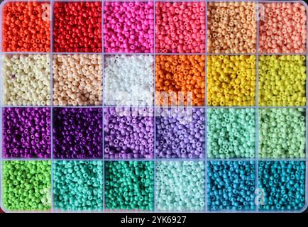 Perles de verre colorées dans une boîte. Belles perles de verre minuscules pour la broderie. Perles dans la boîte de compartiment pour l'artisanat. Banque D'Images