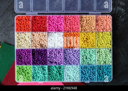 Perles de verre colorées dans une boîte. Belles perles de verre minuscules pour la broderie. Perles dans la boîte de compartiment pour l'artisanat. Banque D'Images