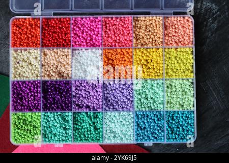 Perles de verre colorées dans une boîte. Belles perles de verre minuscules pour la broderie. Perles dans la boîte de compartiment pour l'artisanat. Banque D'Images