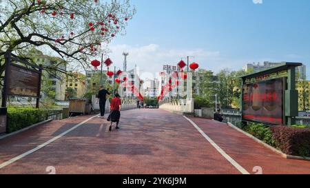 Un pont pittoresque orné de lanternes rouges vibrantes, créant une atmosphère festive à Yichun, en Chine. Banque D'Images