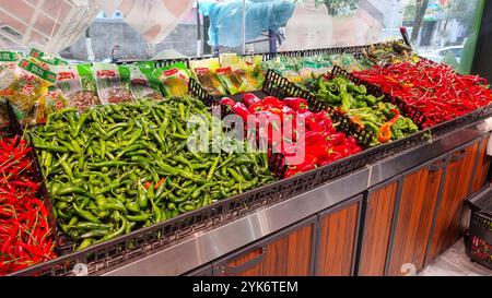 Une exposition vibrante de piments frais dans un supermarché en Chine. Le stand est rempli de différents types de piments. Banque D'Images