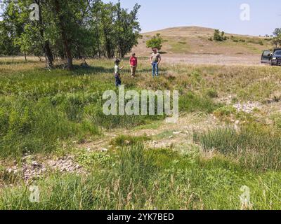 John et Melanie Cammack, propriétaires du ranch de Buffalo de Cammack, exploitent un ranch de buffle de 13 000 acres avec 600 vaches mères, à Stoneville, Dakota du Sud, le 21 juillet 2021. John Cammack est un éleveur de quatrième génération. Le principal défi de cette année est la sécheresse et la meilleure façon d'adapter les pratiques de pâturage au manque d'eau. Pendant les saisons normales, les nombreux ruisseaux du ranch coulent avec de l'eau. Comme les buffles tournent d'un champ à l'autre, ils doivent souvent traverser un ou plusieurs ruisseaux chaque jour. M. Cammack affirme que, d’abord et avant tout, l’utilisation de l’USDA présente des avantages financiers. Il est suivi par l'utilisation du NRCS Banque D'Images