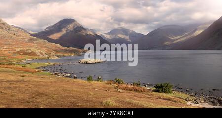 Vue sur Wastwater dans le Lake District, Cumbria, Angleterre, avec Yewbarrow et Great Gable s'élevant au-dessus de la végétation du rivage. Banque D'Images