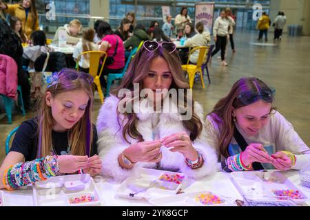 Toronto, Ontario, Canada. 15 novembre 2024. Les Swifties fabriquent des bracelets à la station Bracelet Exchange pendant le Taylgate '24, au Metro Convention Centre. Taylgate '24 est une expérience de fans sur le thème de Taylor Swift à Toronto qui se tient en parallèle de ses six concerts à guichets fermés. L'événement offre des activités telles que le chant-alongs, DJ sets et la fabrication de bracelets d'amitié, créant un centre de célébration pour les Swifties de tous âges. (Crédit image : © Shawn Goldberg/SOPA images via ZUMA Press Wire) USAGE ÉDITORIAL SEULEMENT! Non destiné à UN USAGE commercial ! Banque D'Images