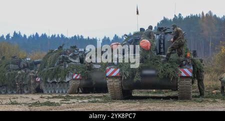 Les soldats de l'armée allemande affectés à la 295e brigade franco-allemande camouflent un PzH 2000 A1 en préparation d'un exercice de tir réel pendant le Front dynamique 25 sur la zone d'entraînement de Grafenwöhr, Bavière, Allemagne, 17 novembre 2024. Dynamic Front se déroule du 4 au 24 novembre en Finlande, Estonie, Allemagne, Pologne et Roumanie, et démontre la capacité de l’OTAN à partager des informations sur les cibles des missions de tir et des graphiques opérationnels de l’Arctique à la mer Noire. Il accroît la létalité de l'Alliance par des incendies de longue distance, renforce la préparation de l'unité dans un environnement conjoint et multinational complexe, et tire parti de Host-n Banque D'Images