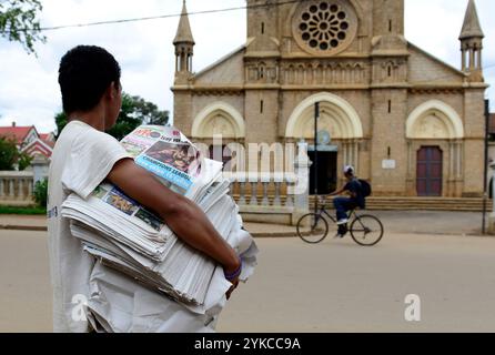 Un malgache vendant des journaux près de la cathédrale d'Antsirabe, Madagascar. Banque D'Images