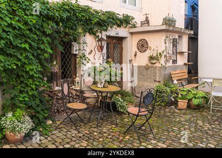 Coin salon idyllique avec table en fer et chaises en face d'une maison dans une ruelle dans la vieille ville de Bremgarten, canton d'Argovie, Suisse Banque D'Images