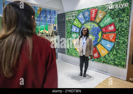 Bakou, Azerbaïdjan, Azerbaïdjan. 16 novembre 2024. Une femme se tient debout devant un panneau d’affichage SDG fait de bouchons de bouteilles en plastique et en forme de logo SDG dans la section Pavillon du site de la COP29 tenue au stade olympique de Bakou. Les objectifs de développement durable (ODD) font partie intégrante du maintien de la cohésion entre les pays membres, comprenant 17 objectifs ciblés affectés par les défis mondiaux actuels, de l’environnement à la pauvreté, des droits de l’homme à l’économie et plus encore. Depuis le COVID, il y a eu un «rattrapage» sur le temps perdu et une lutte contre la division croissante dans le monde entier. (Crédit image : © Bian Banque D'Images