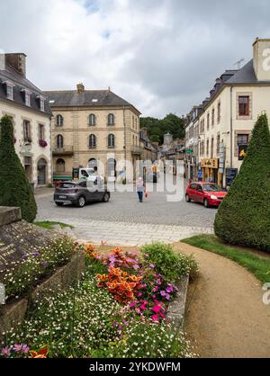 Pontrieux, France - 22 juillet 2024 : une pittoresque place de la ville européenne avec ses rues pavées, entourée de bâtiments historiques. Les voitures sont garées et un PER Banque D'Images