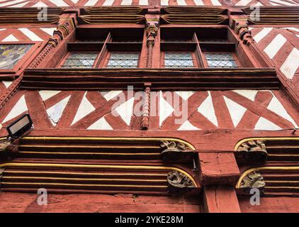 Façade historique avec poutres en bois complexes peintes en rouge et blanc. Les détails architecturaux comprennent des sculptures ornées et des éléments décoratifs, Banque D'Images