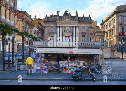 Kiosque à Piazza Stesicoro avec vue sur l'amphithéâtre romain et l'église de San Biagio. Une Vespa est garée devant le kiosque. Catane, Sicile. Banque D'Images