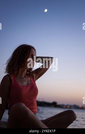 Femme en silhouette sous la lune du soir Banque D'Images