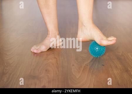 détail des pieds danseurs de ballet avec balle pour massage sur un plancher en bois Banque D'Images