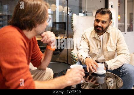 Deux professionnels s'engagent dans une discussion animée dans un espace de coworking moderne et créatif L'atmosphère détendue favorise la collaboration et l'innovation, l'esprit Banque D'Images