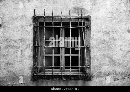 photographie d'une vieille fenêtre grunge noire et blanche avec grille rouillée Banque D'Images