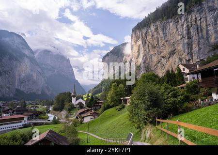Une vue imprenable sur le village de Lauterbrunnen en Suisse, avec des maisons pittoresques, une église traditionnelle et des falaises spectaculaires avec des cascades Banque D'Images