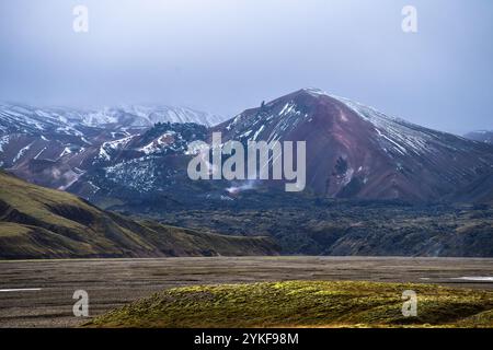 Une image époustouflante capturant l'interaction spectaculaire des couleurs et des textures dans les Highlands d'Islande, avec des sommets glacés et des vallées luxuriantes. Banque D'Images