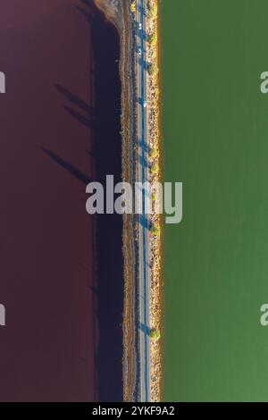 Une prise de vue aérienne qui capture les contrastes naturels saisissants de Riotinto, avec des eaux marron et vertes vives clairement divisées par une route avec plusieurs voitures Banque D'Images