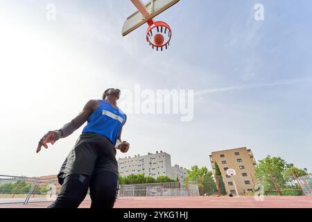 joueur de basket-ball noir dunking sur un terrain extérieur Banque D'Images