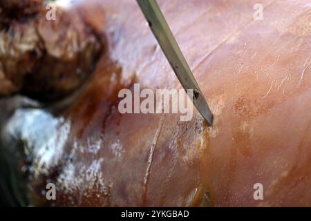 Gros plan du rôti traditionnel de porc entier sur broche extérieure avec couteau, en Slovaquie, Europe centrale Banque D'Images
