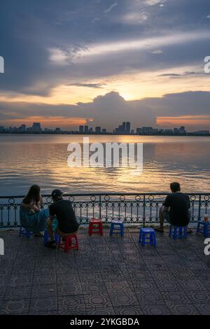 Il s'agit d'une vue au bord du lac de l'Ouest avec des gens regardant le coucher du soleil le 02 juillet 2023 à Hanoi, Vietnam Banque D'Images