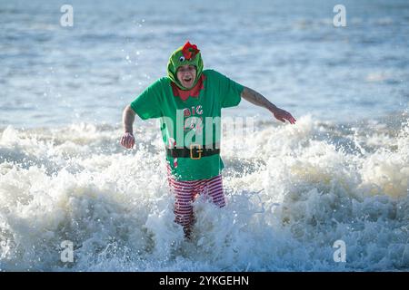 Brighton, Royaume-Uni. 25 décembre 2019. Des centaines de personnes se rassemblent sur la plage de Brighton pour leur baignade annuelle le jour de Noël. Malgré les préoccupations du conseil en matière de sécurité et les grosses vagues de la mer, plusieurs nageurs ont pris part à la baignade de Noël de cette année au large de la plage de Brighton dans leurs bikinis, shorts de bain et tenues du Père Noël Banque D'Images