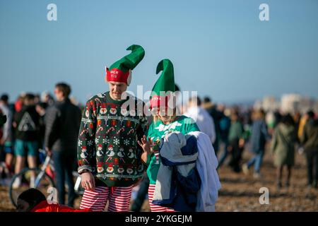 Brighton, Royaume-Uni. 25 décembre 2019. Des centaines de personnes se rassemblent sur la plage de Brighton pour leur baignade annuelle le jour de Noël. Malgré les préoccupations du conseil en matière de sécurité et les grosses vagues de la mer, plusieurs nageurs ont pris part à la baignade de Noël de cette année au large de la plage de Brighton dans leurs bikinis, shorts de bain et tenues du Père Noël Banque D'Images