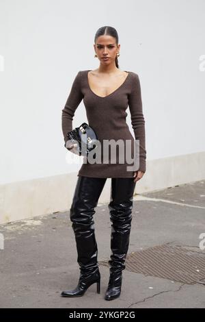 MILAN, ITALIE - 21 SEPTEMBRE 2024 : femme avec une robe en laine marron et des bottes à talons hauts en cuir noir avant le défilé Ferragamo, style de rue Milan Banque D'Images