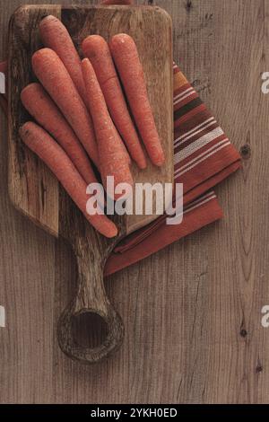 Carottes fraîches sur une planche à découper, table en bois, carottes crues, pas de gens Banque D'Images