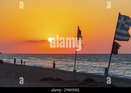 Drapeaux devant le plus beau coucher de soleil à Ialysos Beach sur Rhodes Island Grèce Banque D'Images