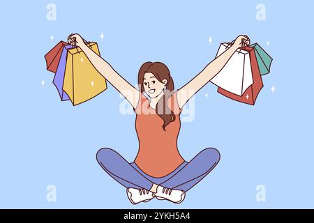 Femme avec des paquets multicolores des magasins de vêtements s'assoit avec ses bras séparés après des achats réussis. Fille qui a gagné à la loterie shopping montre au loin Thi Banque D'Images