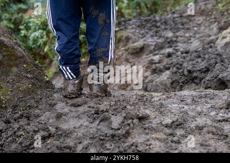 Un gros plan d'un sentier boueux et d'un homme qui a des bottes boueuses, debout immobile à Khumbu, Népal. Banque D'Images