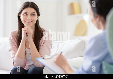 Femme souriante parlant à l'entraîneur de bien-être au sujet de la motivation Banque D'Images