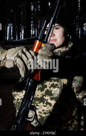 Une femme étudie les armes automatiques lors d'un entraînement militaire du groupe mobile féminin de défense aérienne 'sorcières de Bucha'. Les 'sorcières Bucha' protègent le ciel au-dessus de l'Ukraine. Les « sorcières Bucha » sont une unité mobile volontaire de défense aérienne en Ukraine, composée principalement de femmes. Opérant dans la région de Bucha, ils se spécialisent dans la tactique anti-drone et participent régulièrement à des exercices pour améliorer leurs compétences. Ils jouent un rôle vital dans la protection du ciel ukrainien. Au milieu de la guerre en cours, les femmes ukrainiennes assument des responsabilités cruciales, à la fois sur la ligne de front et dans le maintien de la func sociétale Banque D'Images