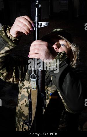 Une femme étudie les armes automatiques lors d'un entraînement militaire du groupe mobile féminin de défense aérienne 'sorcières de Bucha'. Les 'sorcières Bucha' protègent le ciel au-dessus de l'Ukraine. Les « sorcières Bucha » sont une unité mobile volontaire de défense aérienne en Ukraine, composée principalement de femmes. Opérant dans la région de Bucha, ils se spécialisent dans la tactique anti-drone et participent régulièrement à des exercices pour améliorer leurs compétences. Ils jouent un rôle vital dans la protection du ciel ukrainien. Au milieu de la guerre en cours, les femmes ukrainiennes assument des responsabilités cruciales, à la fois sur la ligne de front et dans le maintien de la func sociétale Banque D'Images