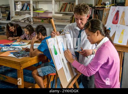 École Art Class design de mode avec professeur et adolescente de fille travaillant sur son projet de conception de mode dessins de vêtements dans la classe d'art scolaire Banque D'Images