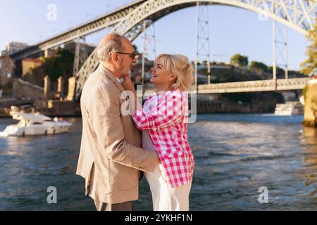 Couple aimant profitant d'un moment romantique au bord de la rivière sous un pont Banque D'Images