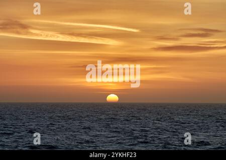 Le soleil se couche magnifiquement sur l'horizon dans la mer. Banque D'Images