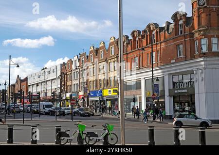 Vue sur la circulation et les petits magasins le long de Acre Lane à Brixton South London SW9 octobre 2024 Angleterre Royaume-Uni KATHY DEWITT Banque D'Images
