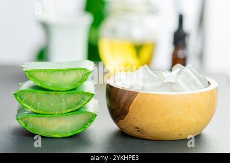 Dans l'image, vous pouvez voir des feuilles de la plante d'aloe vera et de petits morceaux de sa pulpe sur un fond d'ardoise Banque D'Images