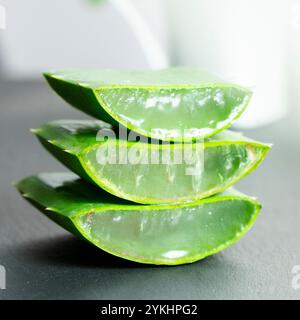 Dans l'image, vous pouvez voir des feuilles de la plante d'aloe vera et de petits morceaux de sa pulpe sur un fond d'ardoise Banque D'Images