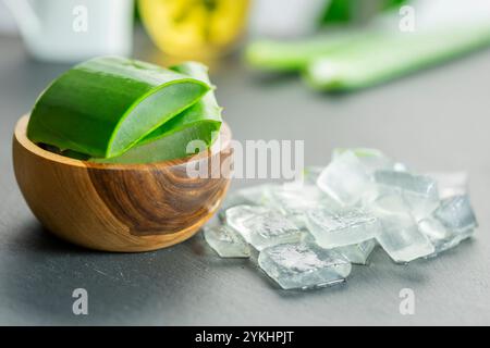 Dans l'image, vous pouvez voir des feuilles de la plante d'aloe vera et de petits morceaux de sa pulpe sur un fond d'ardoise Banque D'Images